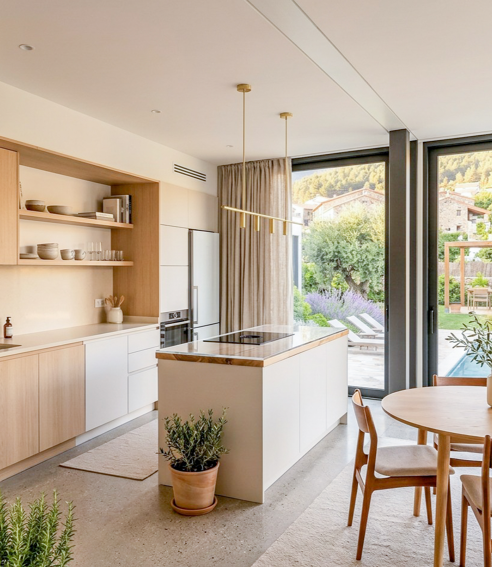 Cocina abierta con isla, zona de comedor y amplias ventanas
